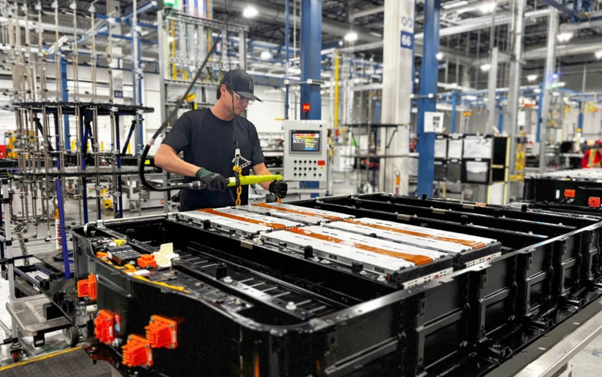 Electric vehicle battery cells being assembled on manufacturing line with recycled materials