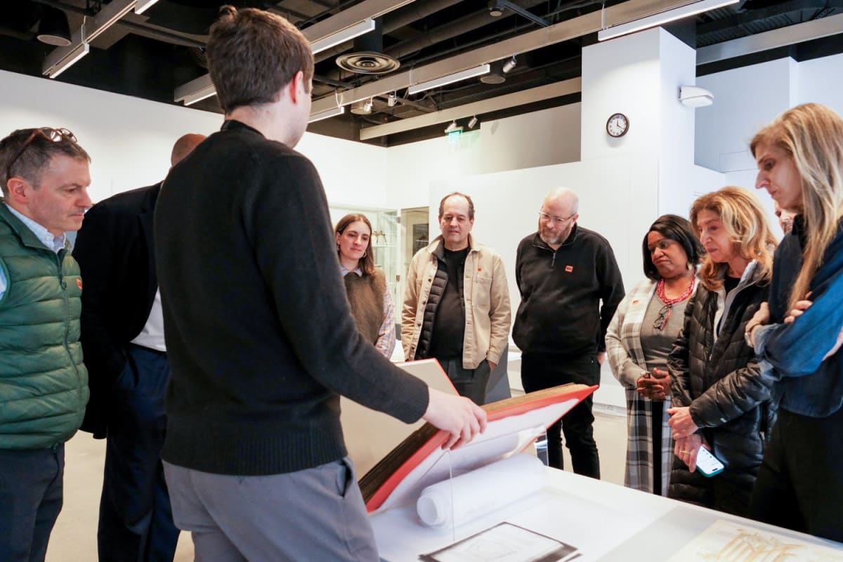 Students and faculty examining Robert Taylor's 1892 architectural thesis at MIT Museum