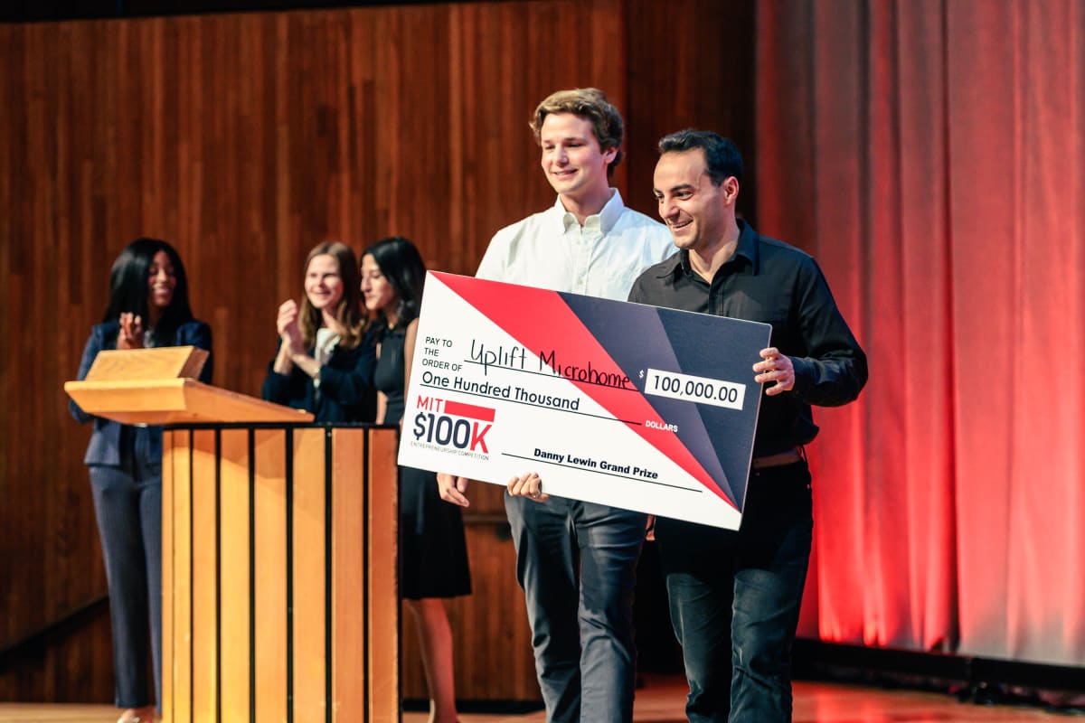 MIT students Charlie Nitschelm and Trevor O'Leary accepting entrepreneurship competition award for disaster housing startup