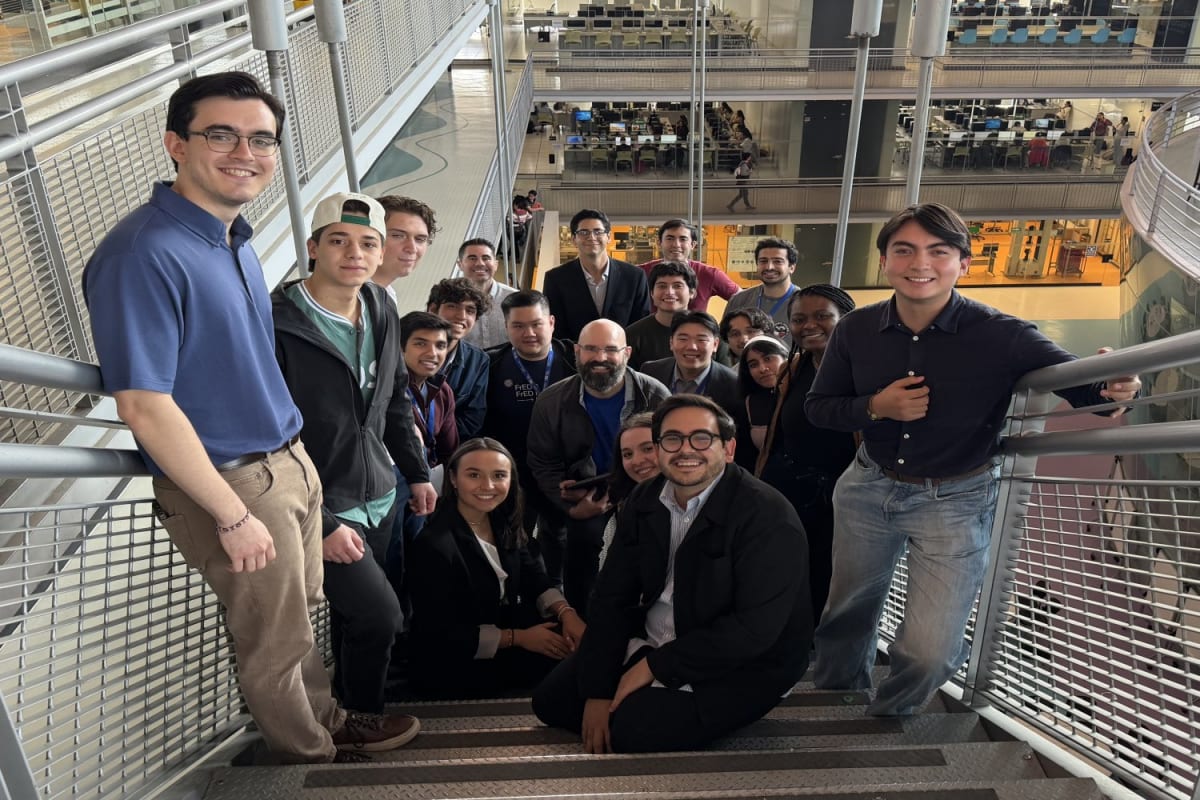 MIT and Tecnológico de Monterrey students pose together with multiple FrED manufacturing devices
