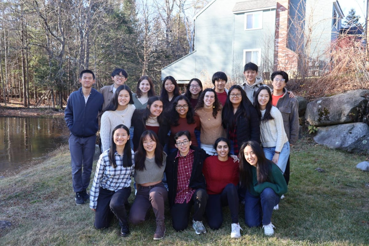 MIT students teaching middle schoolers hands-on science experiments in a bright classroom setting