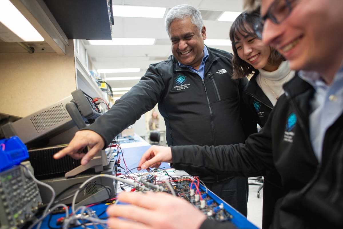 Professor Anantha Chandrakasan working alongside two graduate students in his MIT research laboratory
