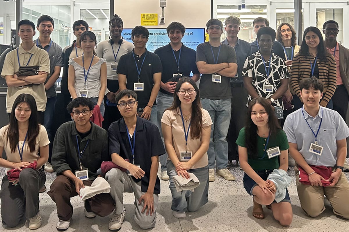 Undergraduate students in clean room bunny suits touring semiconductor fabrication facility