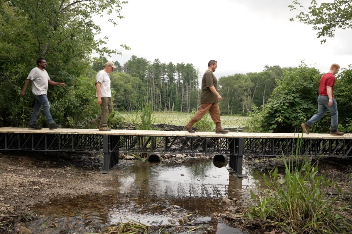 Forty-foot bridge constructed with recycled plastic composite trusses in Massachusetts wetland