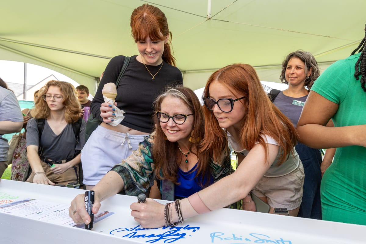 Students and faculty members signing steel beam for Ohio University's new arts education center