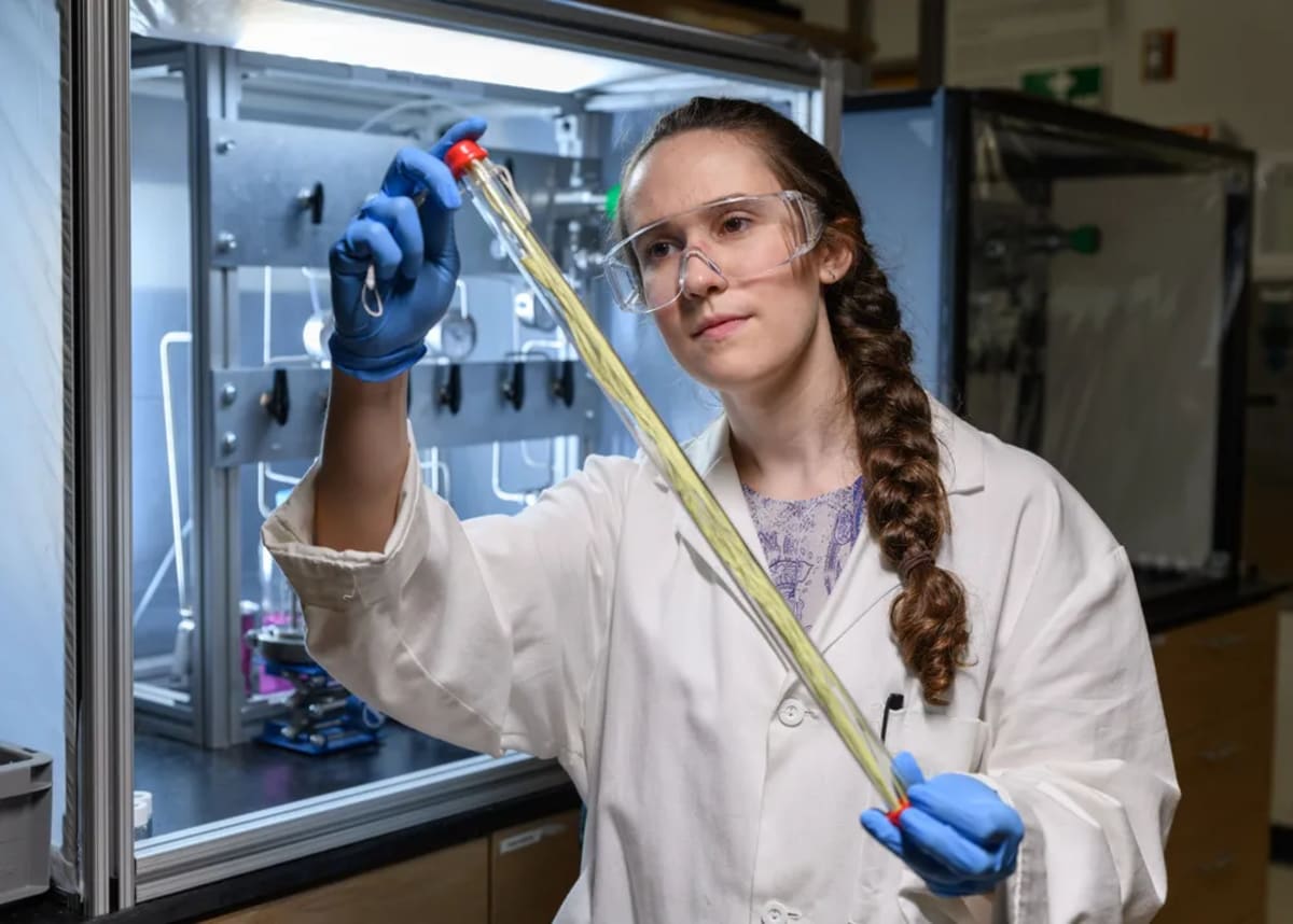Georgia Tech graduate student examining hollow fiber membrane used for chemical separation research