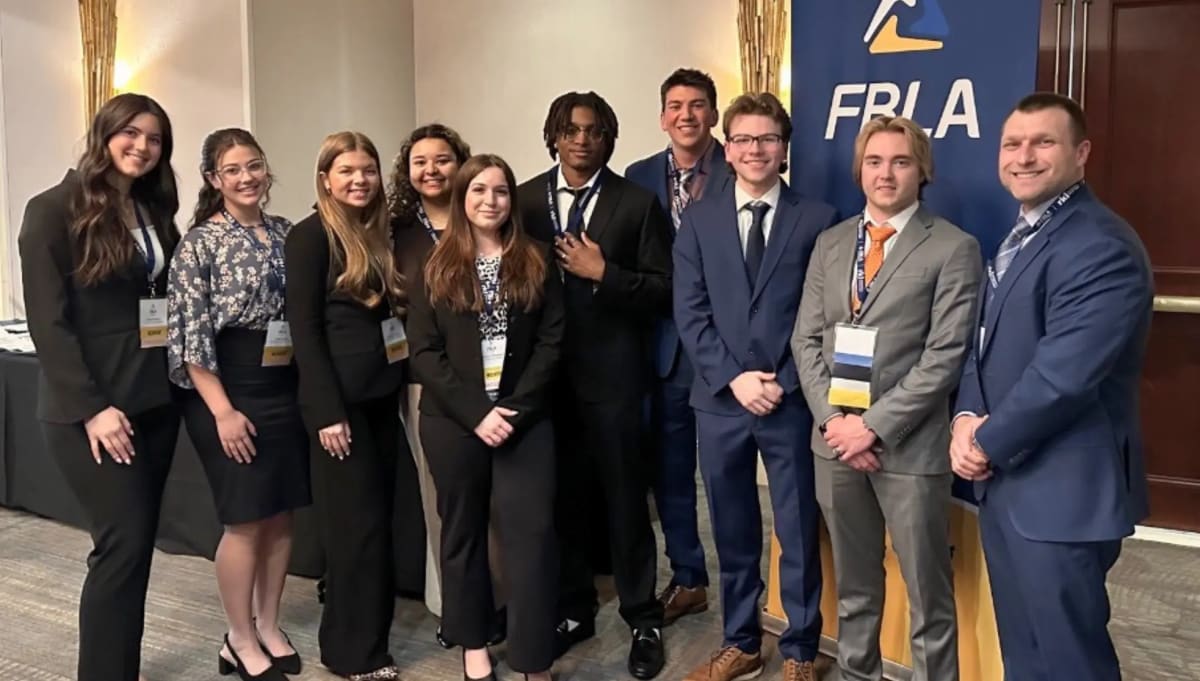 Nine University of Scranton students and professor standing together celebrating FBLA state championship wins