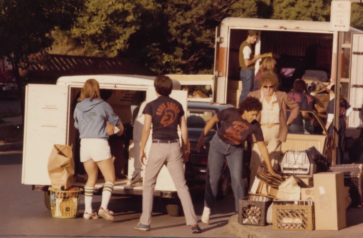 Smiling Syracuse University Goon Squad volunteers helping students unload moving trucks in 1982