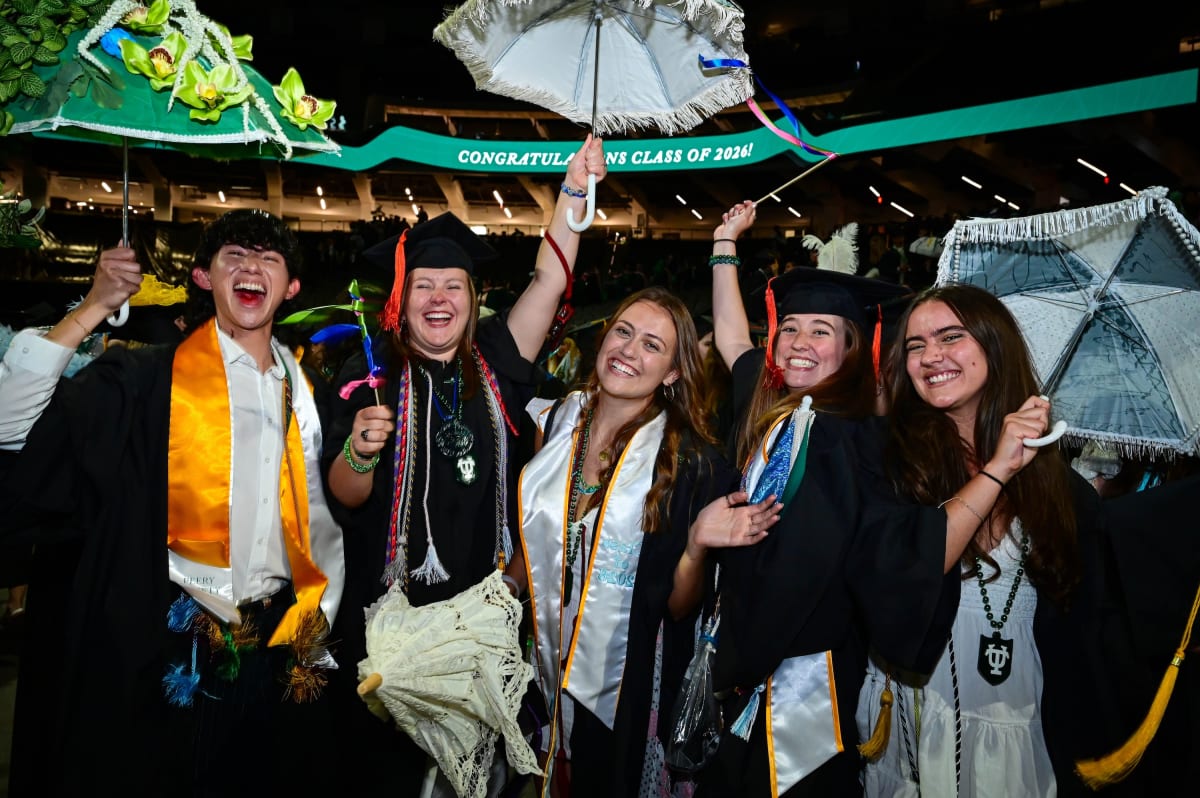 Thousands of Tulane graduates in caps and gowns celebrate at Superdome with colorful LED wristbands