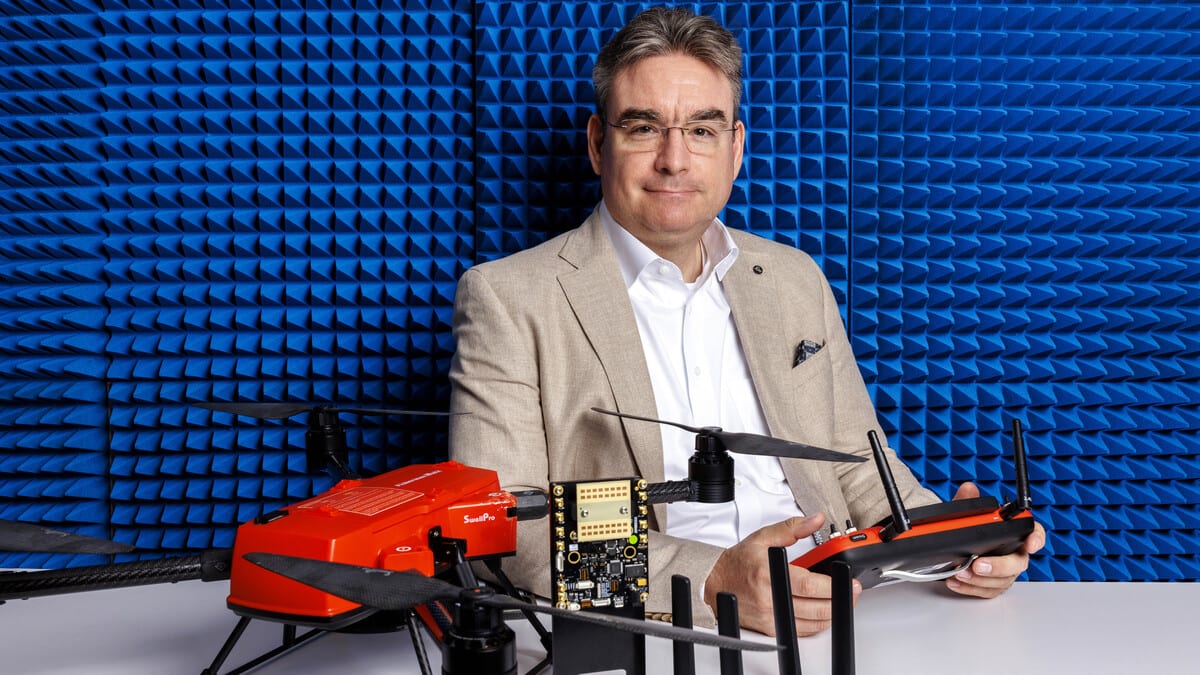 Professor Mehmet Can Vuran standing with wireless connectivity equipment in Nebraska experimental laboratory space