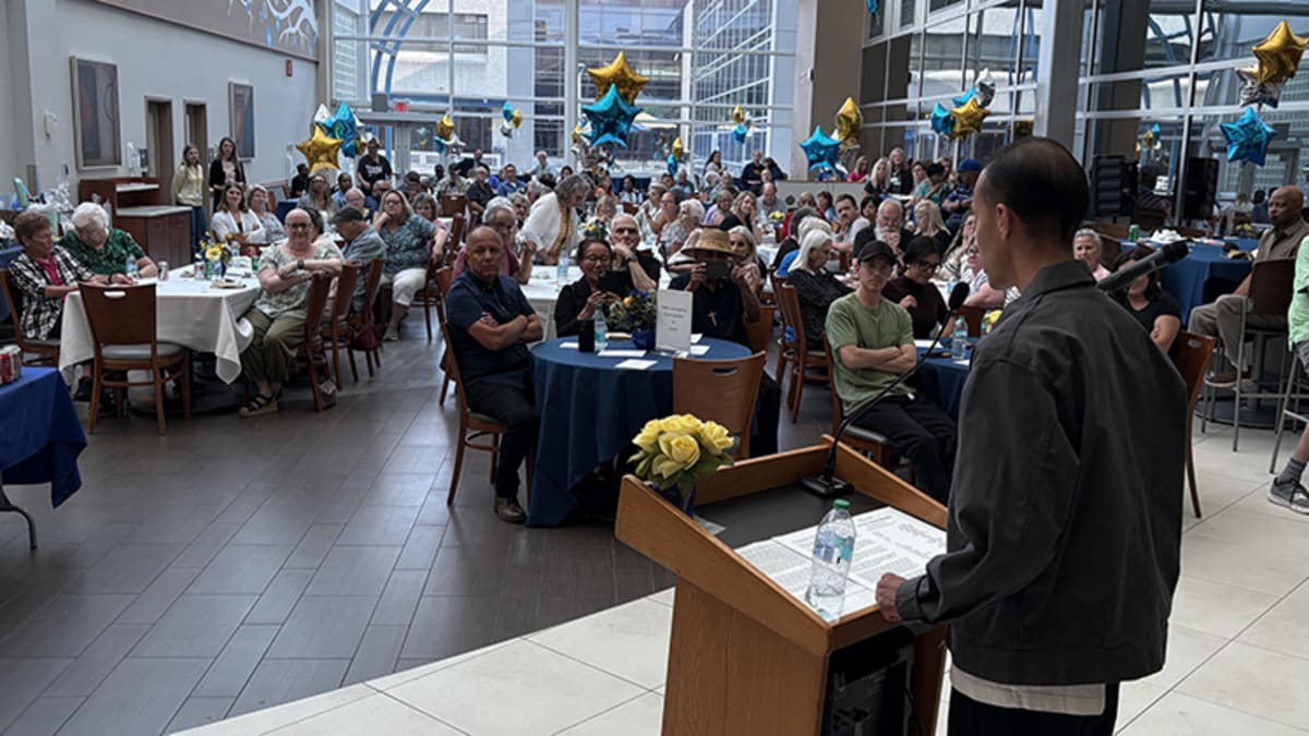 Cancer survivor Leonardo Gomez speaking at podium during Dana Cancer Center survivorship celebration event