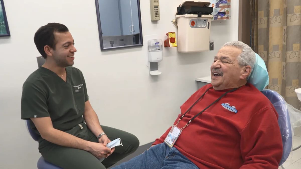 Smiling Veteran patient receiving advanced dental care from VA dentist using modern equipment