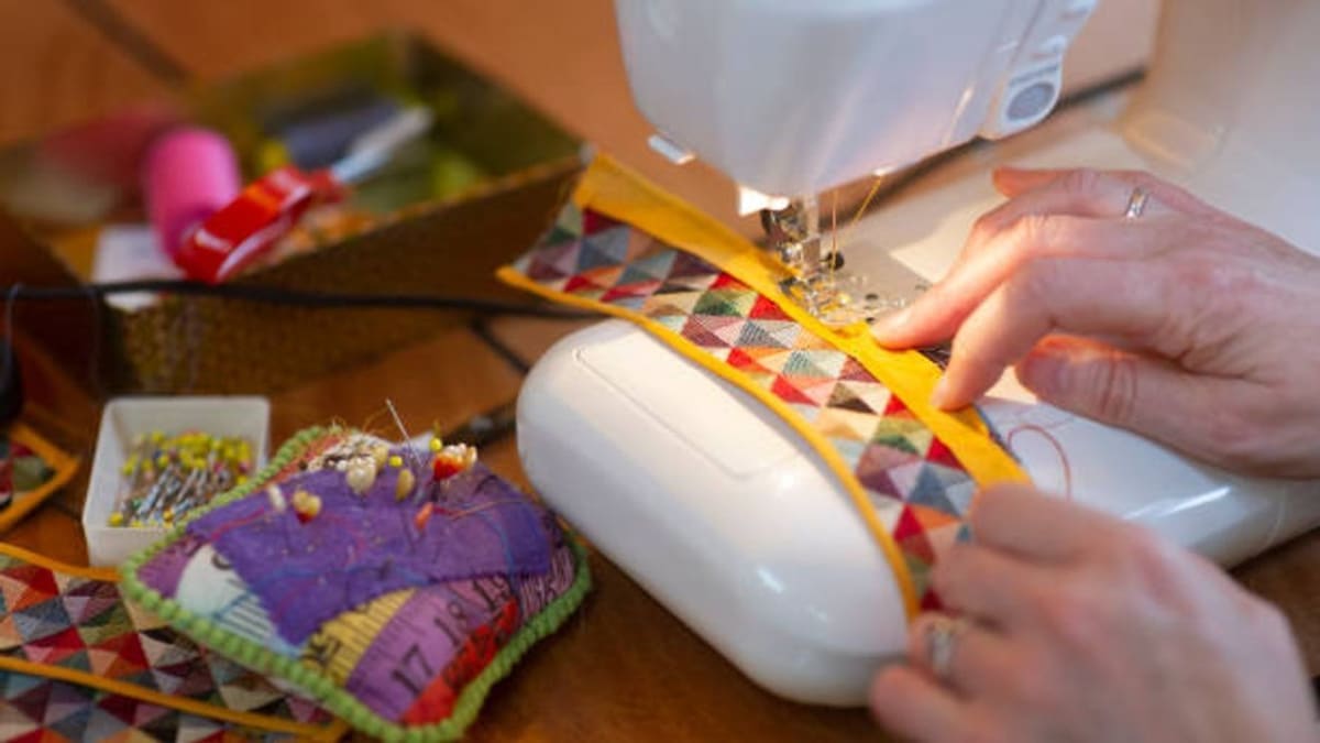 Person using sewing machine during Catholic Charities workforce training program in San Antonio