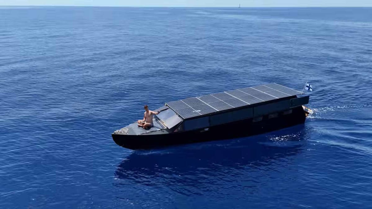 Solar-powered yacht Helios 11 with rooftop panels sailing on open water