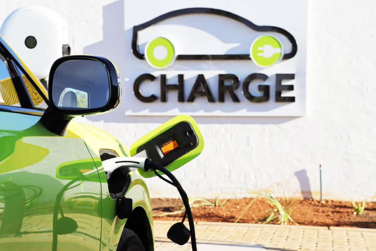 Solar-paneled electric vehicle charging station with yellow roof along South African highway