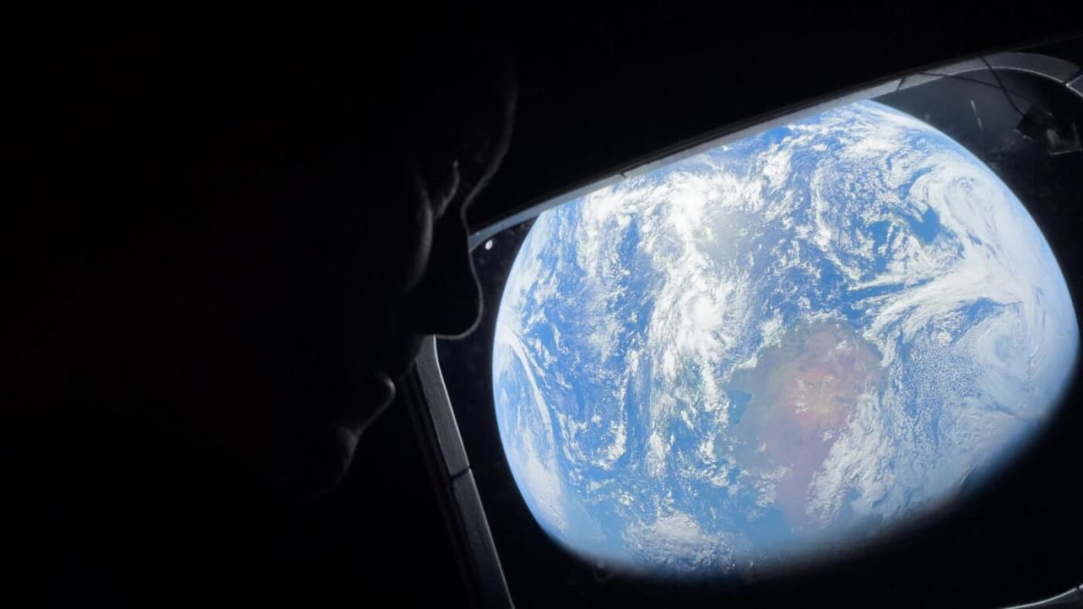 NASA astronaut Reid Wiseman looking at Earth through Orion spacecraft window during historic Artemis II moon mission