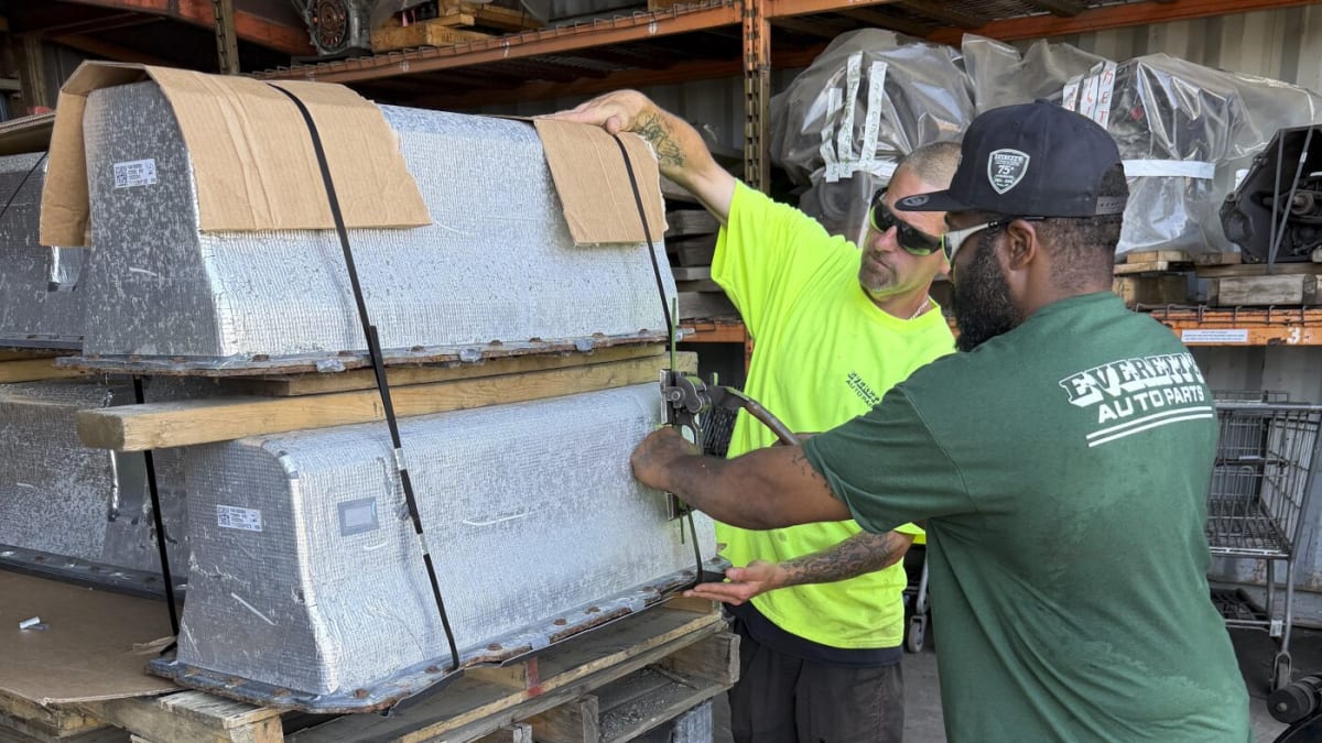 Two large hybrid vehicle batteries strapped to wooden pallet awaiting shipment to recycling facility