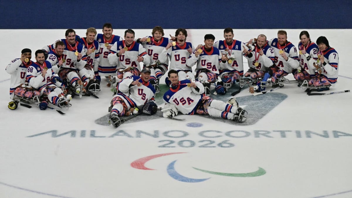 U.S. men's sled hockey team celebrates with raised arms after winning fifth consecutive Paralympic gold medal