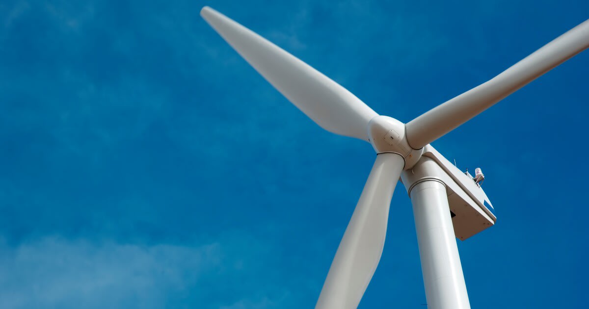 Wind turbines and solar panels generating renewable energy against blue sky in New York