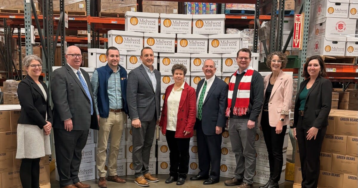 Staff at Midwest Food Bank warehouse celebrating large donation with church representatives