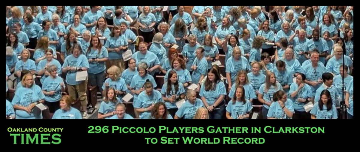 Large group of musicians holding piccolos on stage at Clarkston High School auditorium