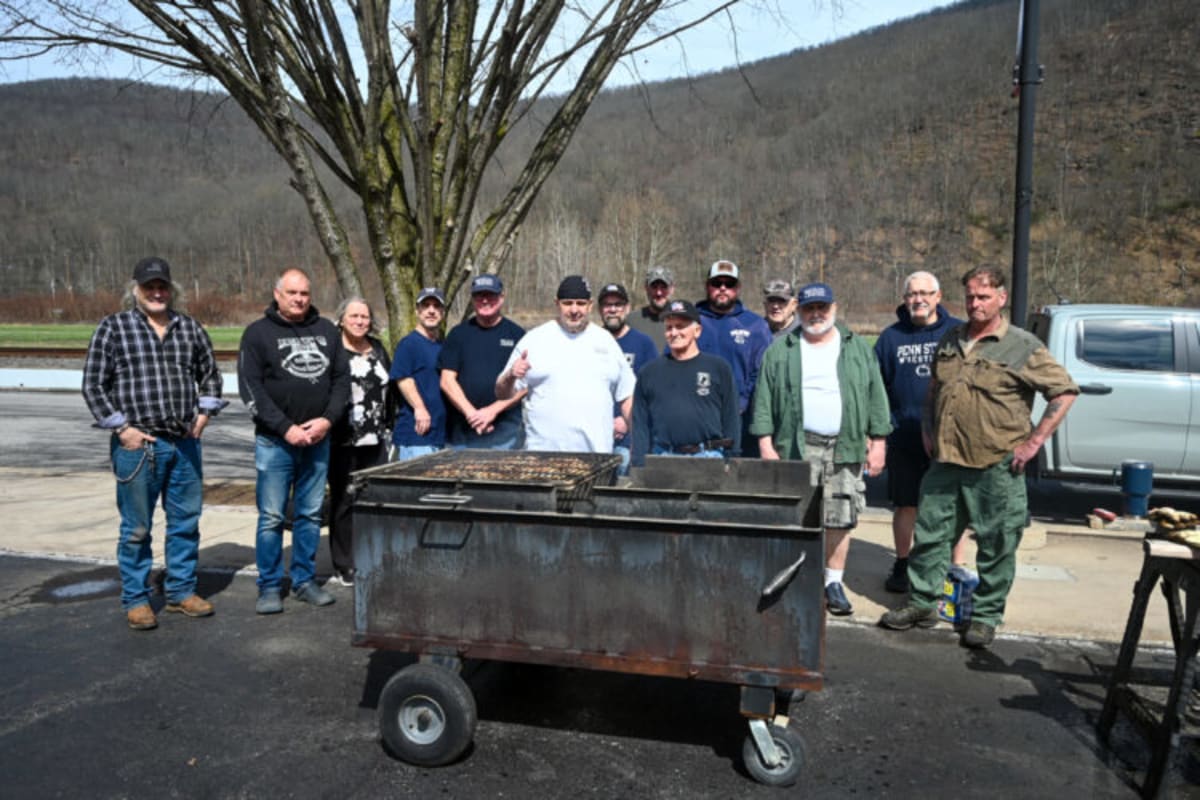 Veterans cooking barbecue chicken on outdoor grills at American Legion Post fundraiser event