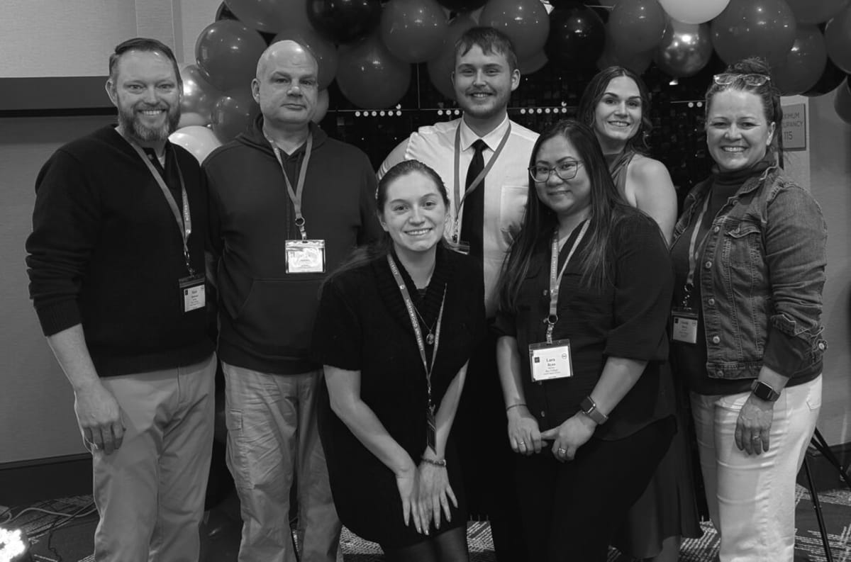 Seven people standing in two rows smiling at Bay College TRIO scholarship recognition event