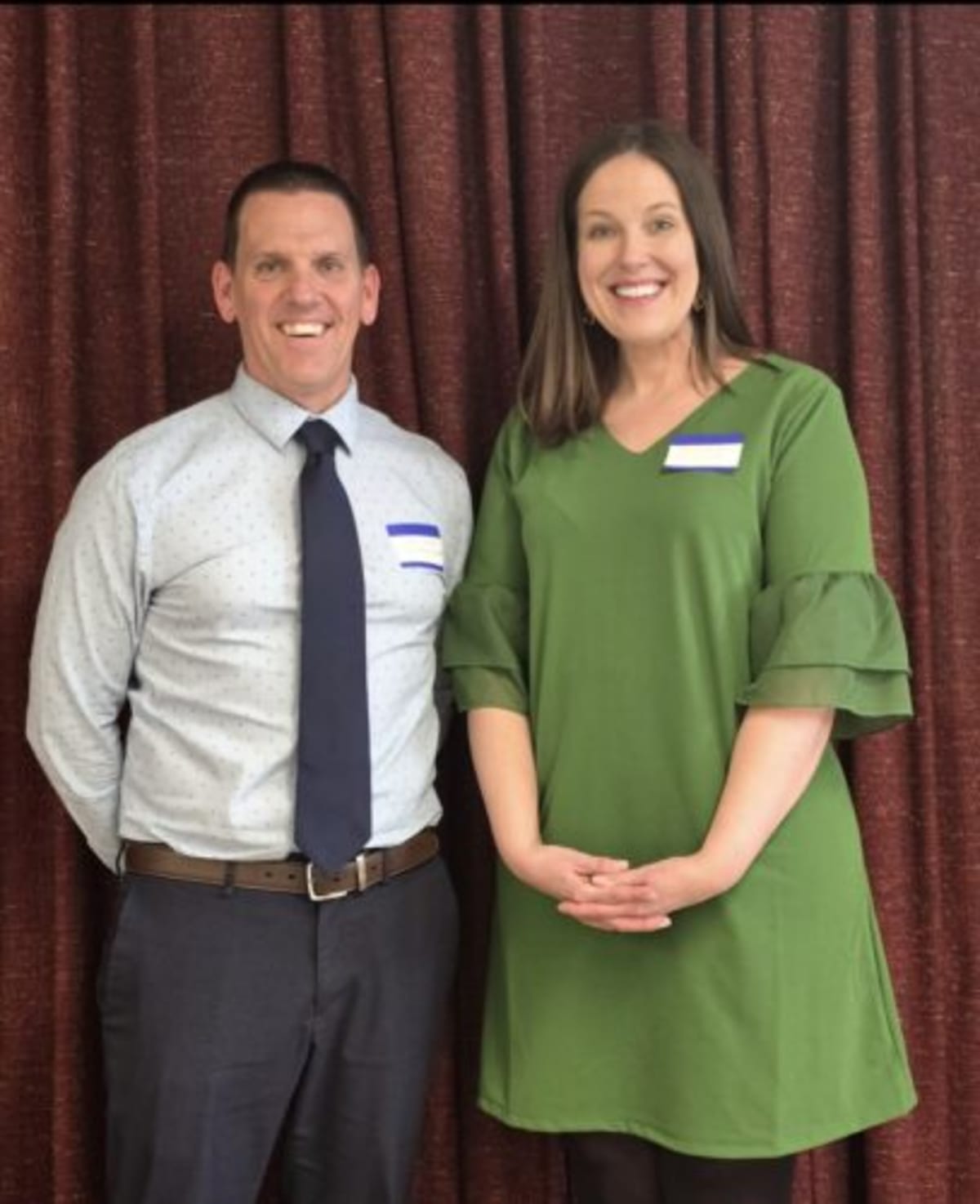 Elementary school intervention specialist with principal holding grant award at educator luncheon