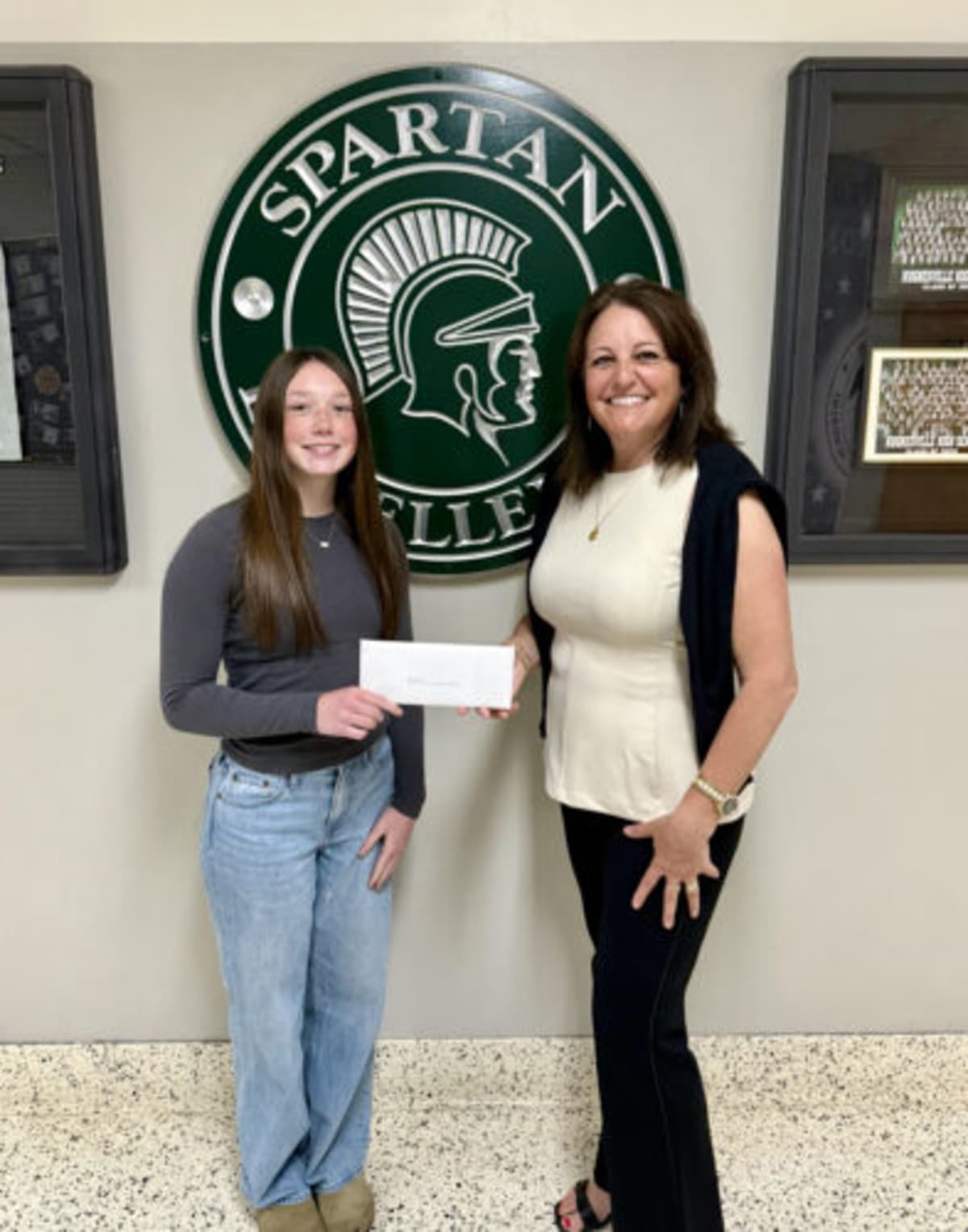 Ava Gorg receives $1,000 scholarship check from Krista Paternostro Bower at school board meeting