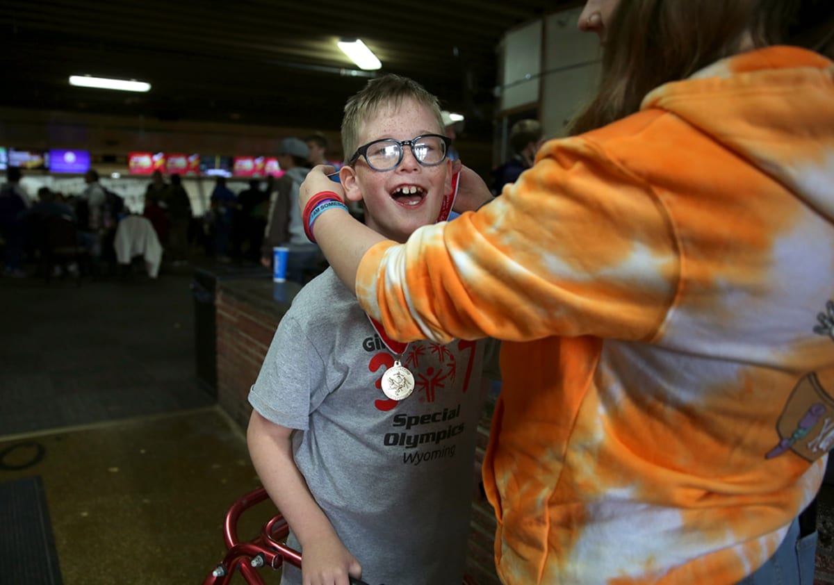Special Olympics athlete competing in summer sports event with volunteer assistance