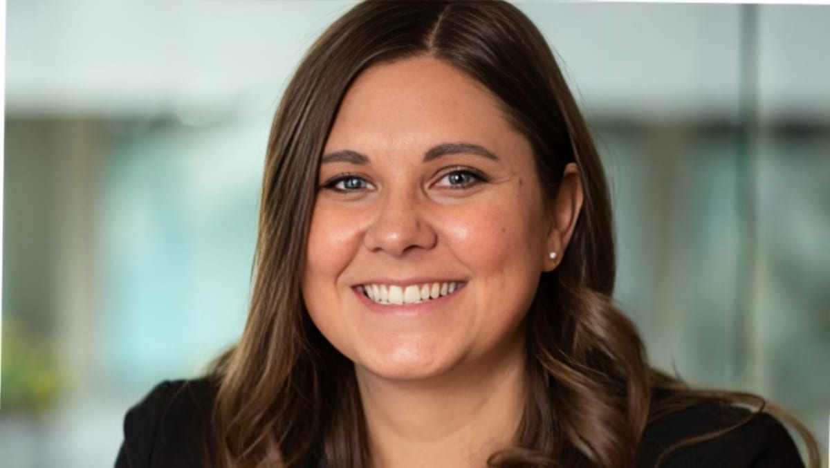 Katie Coleman smiling in professional attire, stage 4 kidney cancer survivor and cancer innovation leader