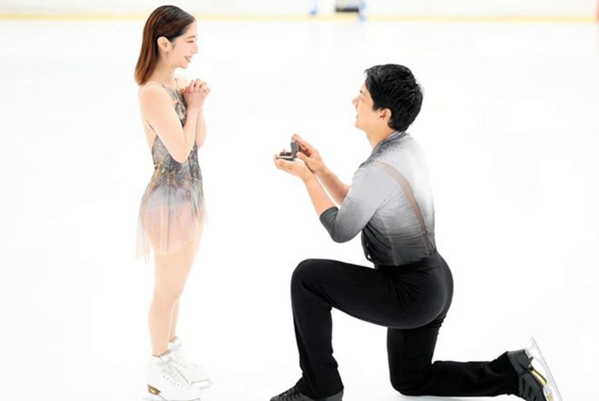 ** Figure skater Ryuichi Kihara kneeling on ice presenting engagement ring to partner Riku Miura
