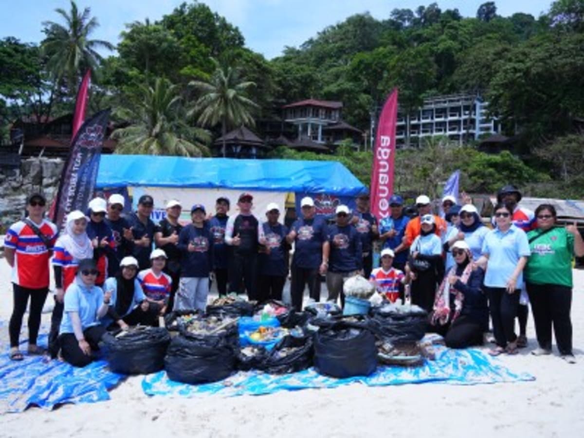 Volunteers collecting marine debris during beach cleanup at Pulau Redang Malaysia