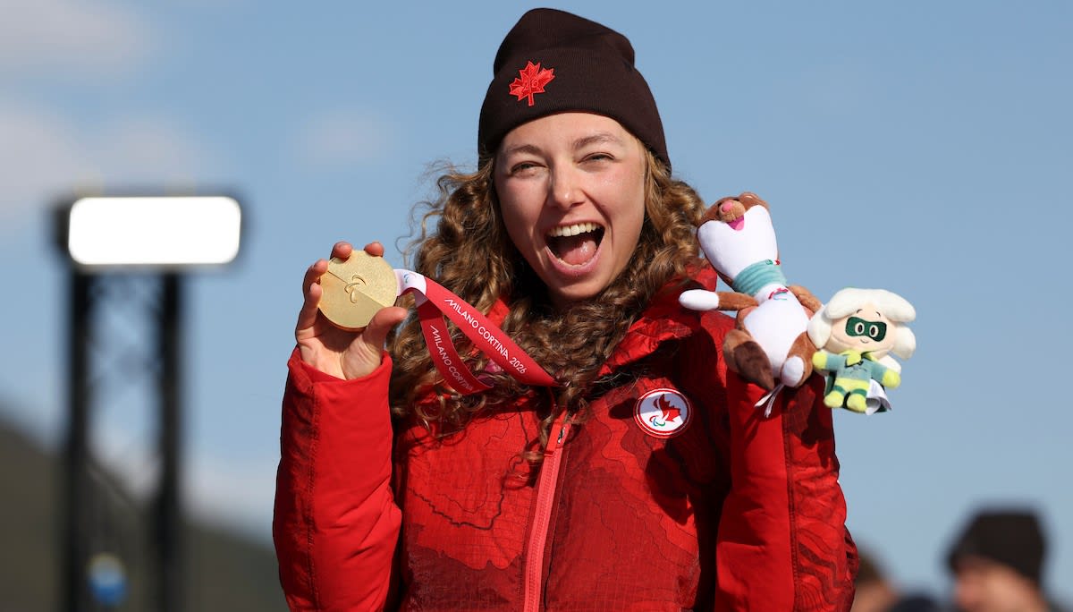 Paralympic skier Natalie Wilkie smiling while holding multiple medals at Milano Cortina 2026 Winter Games