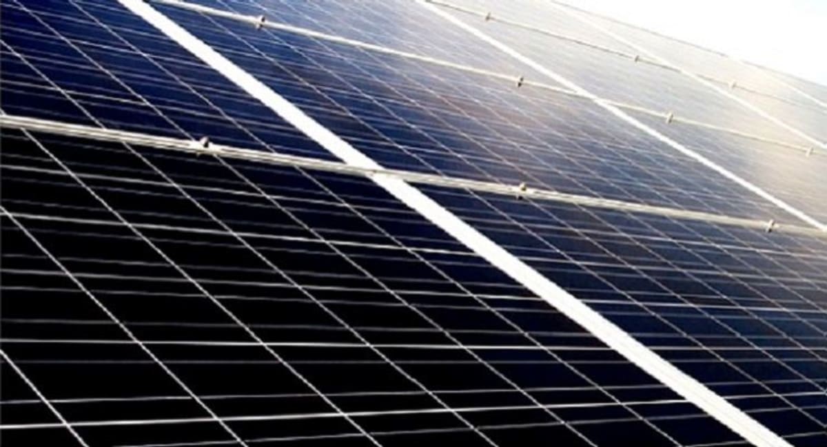 Solar panels installed over school parking lot in sunny California cityscape