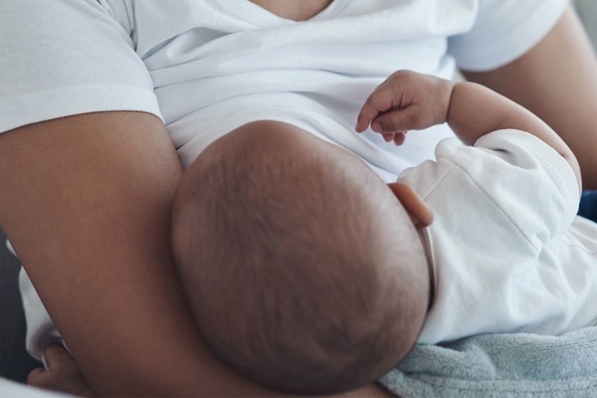 Volunteer comforting new mother learning to breastfeed at Norfolk hospital