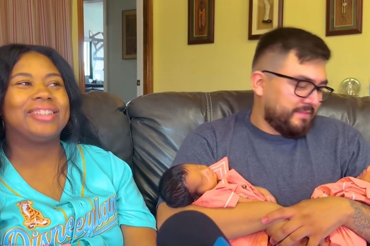 Father Marco Bernal holding two of his newborn triplet sons at home in California