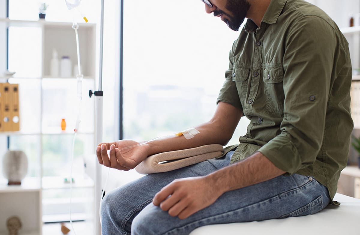 Patient receiving intravenous cancer treatment through IV line in medical setting