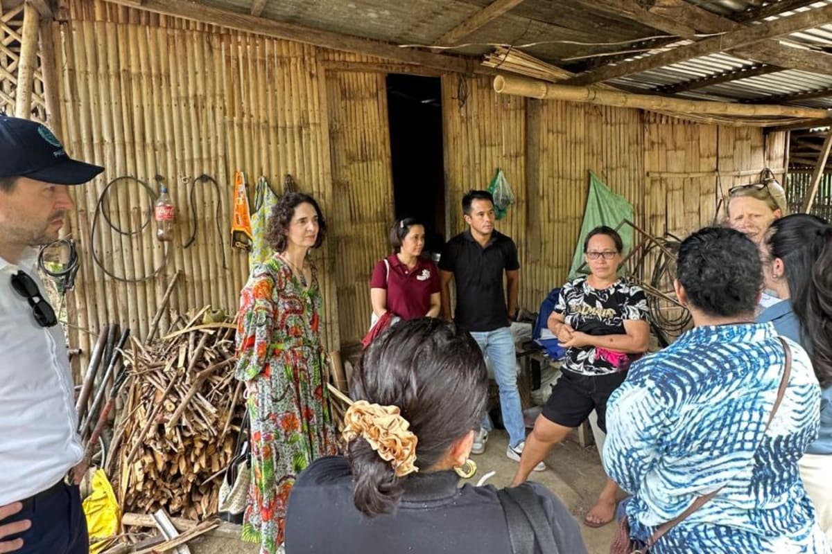 Mary Grace Moreno stands at her solar-powered livestock farm with UN representatives and partners in Iloilo, Philippines