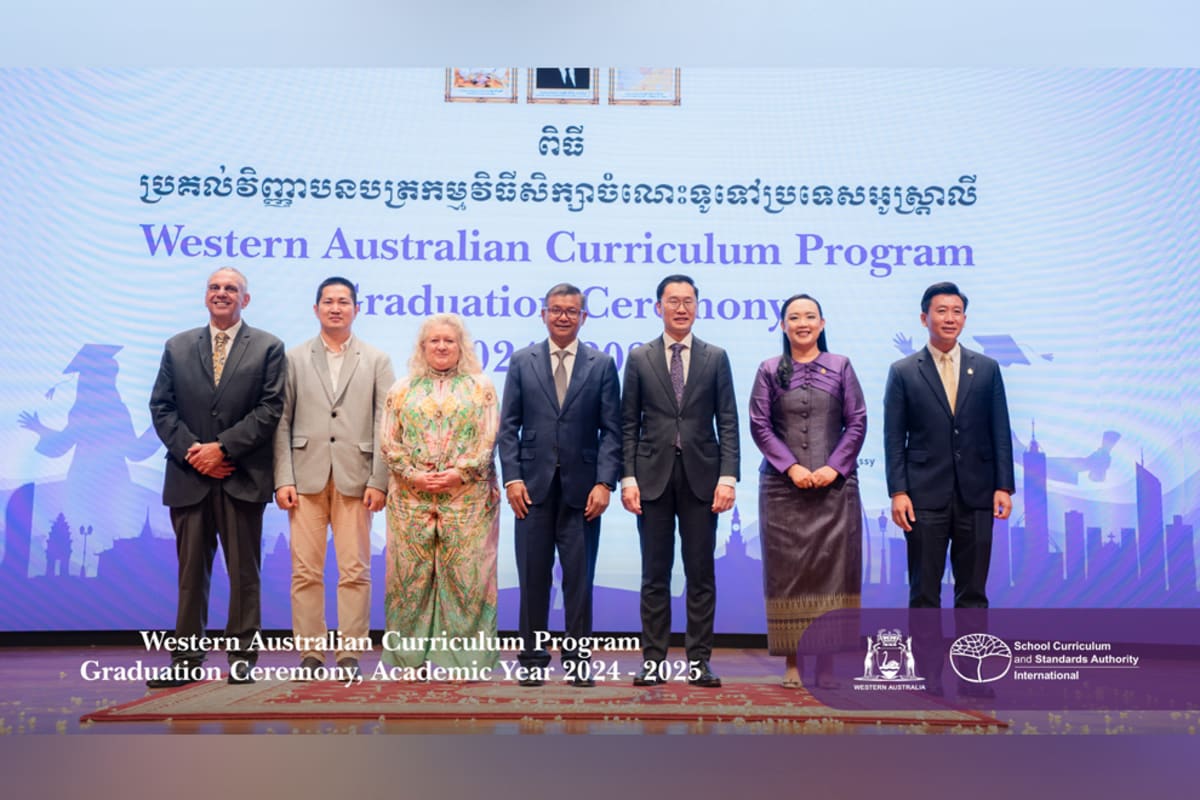 Cambodian students in graduation caps celebrating at Sofitel Phnom Penh ceremony with flags