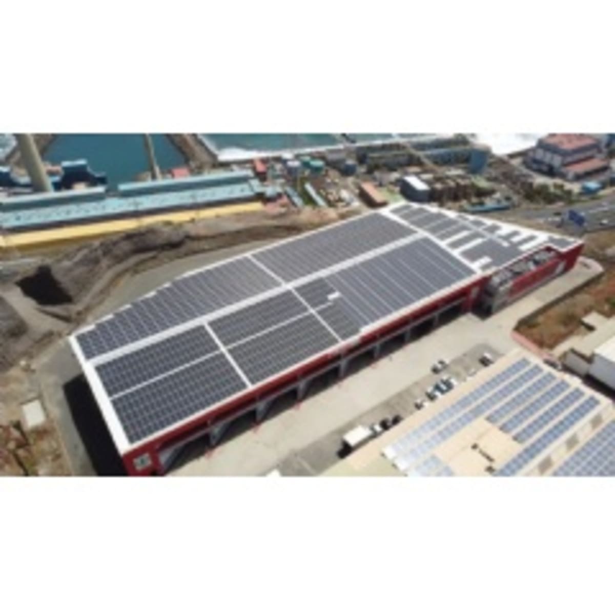 Solar panels installed on rooftop of SPAR supermarket distribution center under blue sky