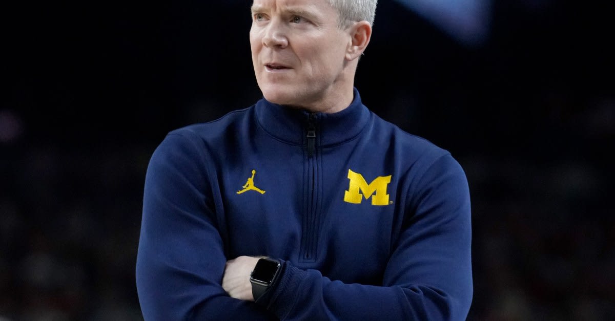Michigan Wolverines basketball team celebrating on court after Final Four victory over Arizona