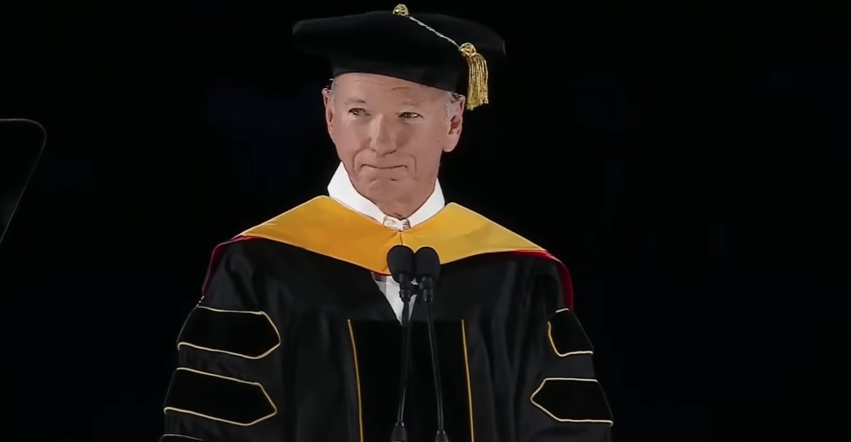 University graduates in caps and gowns at outdoor commencement ceremony raising voices together