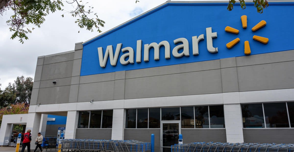 Customer using smartphone to make contactless payment at Walmart checkout register