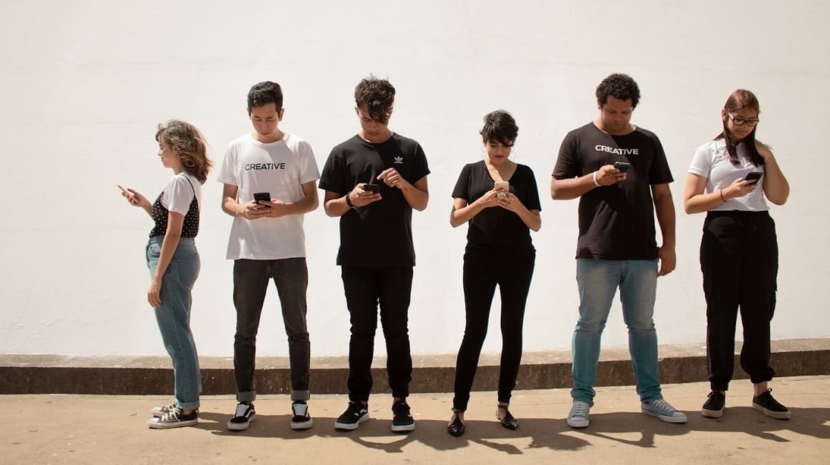 Smartphone displaying social media app icons on screen held in person's hands