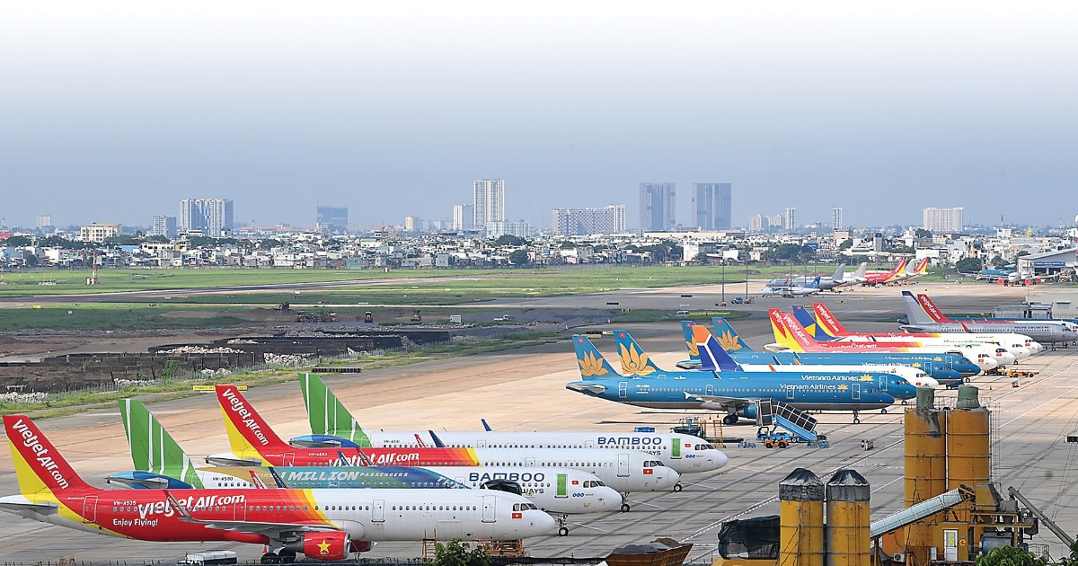 Commercial aircraft at Vietnamese airport terminal with passengers boarding during tourism season
