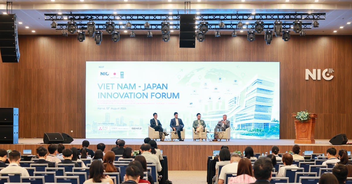 Vietnamese and Japanese officials shaking hands at technology innovation forum in Hanoi