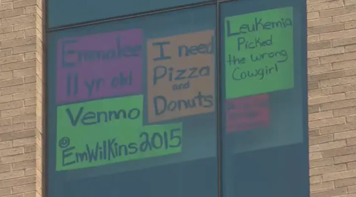 Young girl's handwritten sign taped to hospital window asking for pizza and treats
