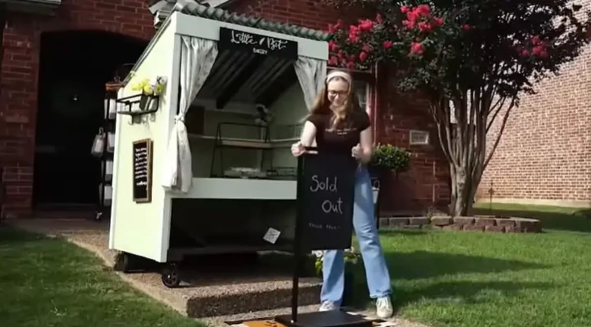 Young woman selling fresh baked bread from bakery cart on residential front porch