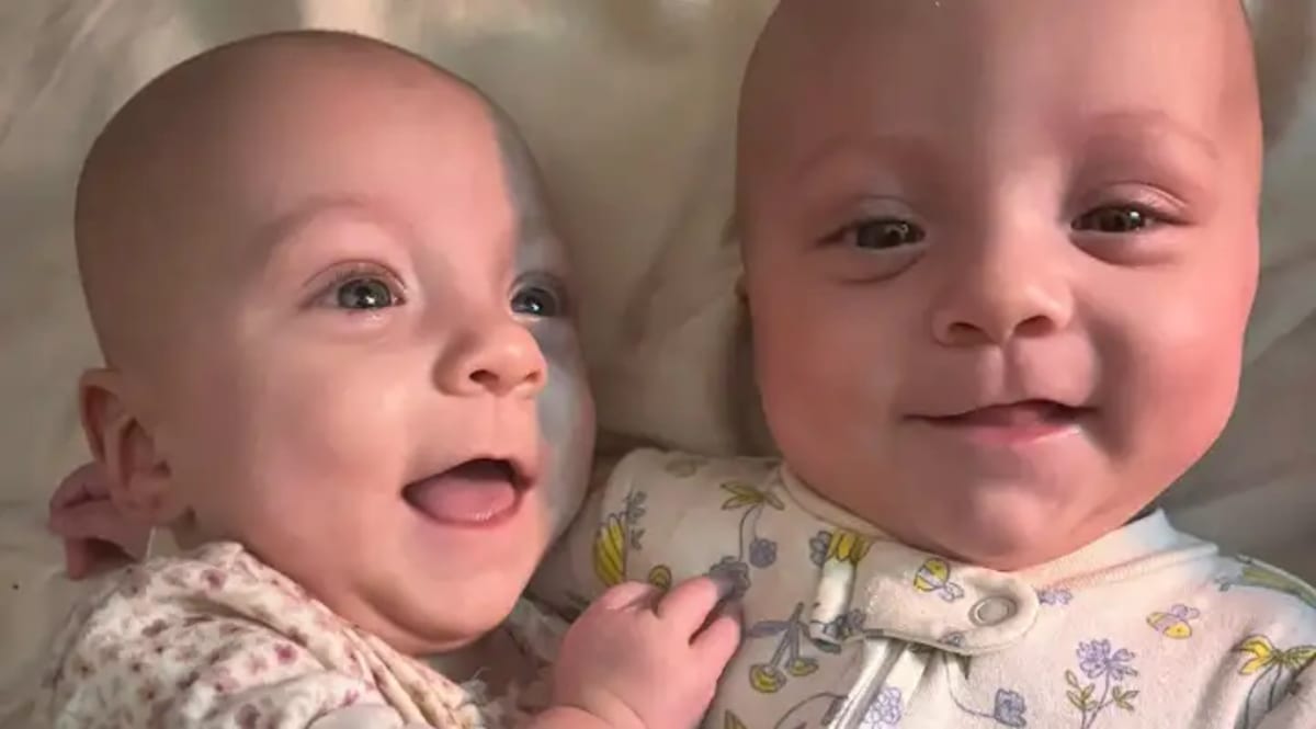 Twin baby girls Fiona and Phoebe smiling together on their first birthday celebration